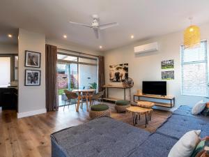 a living room with a blue couch and a table at Miombo Mews in Victoria Falls