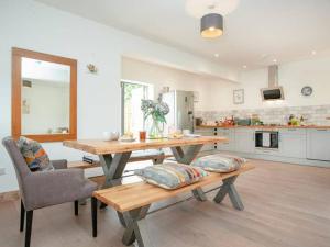 ein Wohnzimmer mit einem Holztisch und einer Küche in der Unterkunft Cosy cottage in the Blackdown hills Devon in Honiton