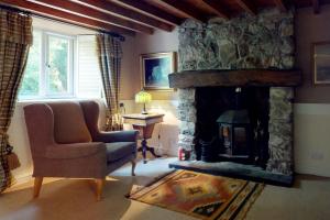 a living room with a chair and a fireplace at Pen Y Bryn in Llanrwst