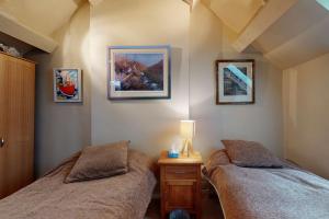 a bedroom with two beds and a lamp and pictures on the wall at Pen Y Bryn in Llanrwst