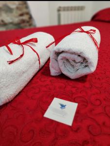 Una toalla en una cama con una tarjeta. en Le Grazie Maisons Genova, en Génova
