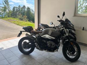 a black motorcycle parked in a room with a window at Karla’s House in Dobje pri Planini