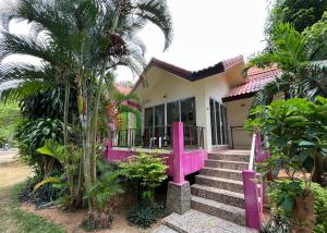 Una casa con pintura rosa en la parte delantera. en Mae Somboon House, en Lamai