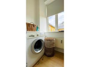 a laundry room with a washing machine and a window at ApartmentInCopenhagen Apartment 664 in Copenhagen