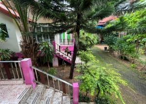 a house with a pink railing next to a tree at Mae Somboon House in Lamai