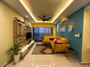 ein Wohnzimmer mit einem gelben Sofa und einer Decke in der Unterkunft Aqilla Homestay in Kuala Selangor