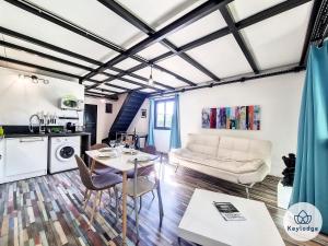 uma sala de estar com um sofá e uma mesa em Corail- Duplex de 45m2 - 10 min de l'aéroport et du centre de Saint Denis em Saint-Denis