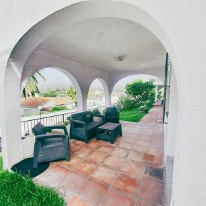an archway with chairs and tables on a patio at Luminosa casa en Nerja in Nerja