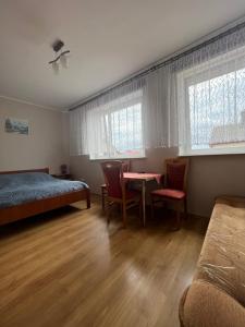 a bedroom with a bed and a table and chairs at Willa Dominik 2 in Jastarnia