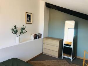 a bedroom with a mirror and a dresser with a mirrorigunigunigun at La Maison Racine 2 - Joli duplex sous les toits in Avignon