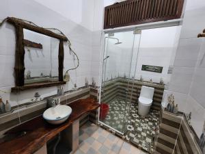 y baño con ducha, aseo y lavamanos. en Tầm Quên Homestay, en Tây Ninh