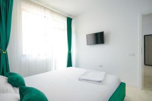 una camera con un letto bianco e una finestra di Green Luxury Apartament a Mamaia Nord - Năvodari