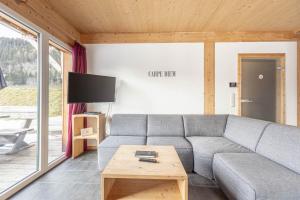ein Wohnzimmer mit einem Sofa und einem Tisch in der Unterkunft Feriendorf Murau by ALPS RESORTS in Murau