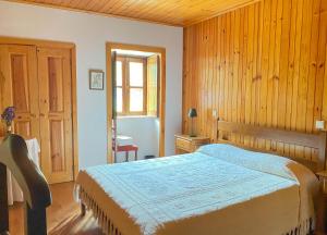 ein Schlafzimmer mit einem Bett und einer Holzwand in der Unterkunft Quinta das Uchas in São Pedro do Sul