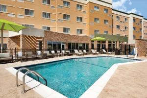 a pool at a hotel with chairs and a building at Courtyard by Marriott El Paso East/I-10 in El Paso