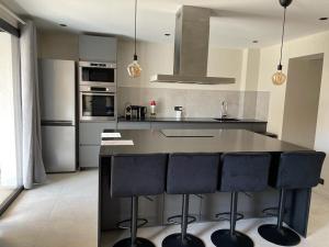 a kitchen with a large island with black bar stools at Résidence Le Provence in Le Lavandou