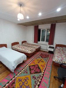 een kamer met 2 bedden en een tapijt bij Farmer's Pond House in Koysary