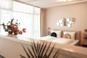 een slaapkamer met een bed en een raam met een vaas met bloemen bij Hotel bij Jacob in Enschede