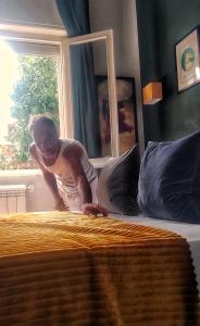 un hombre de pie junto a una cama en un dormitorio en I Levrieri b&b, en Torre del Lago Puccini