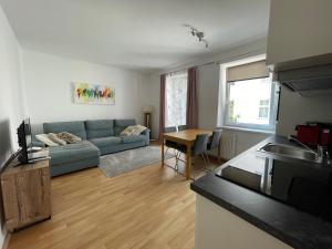 2 Schlafzimmer Apartment في لينز: غرفة معيشة مع أريكة زرقاء وطاولة