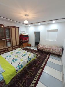een woonkamer met 2 bedden en een tapijt bij Farmer's Pond House in Koysary