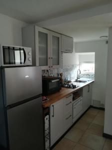 een keuken met een koelkast en een wastafel bij Gîte indépendant neuf, idéal vacances nature au calme, proche rivières, N147 & Civaux in Mazerolles