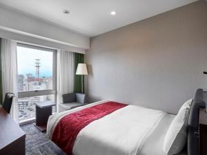 a bedroom with a large bed and a large window at Daiwa Roynet Hotel Toyama-Ekimae in Toyama