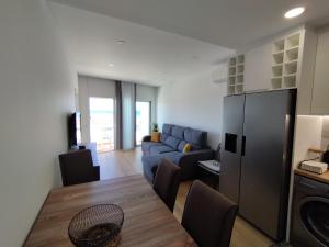 a living room with a table and a blue couch at T2 - Praia Pescadores Frente Mar - Casas & Papéis in Armação de Pêra