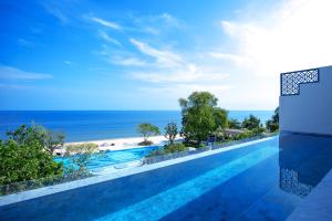 a swimming pool with a view of the beach at Baba Beach Club Hua Hin Luxury Pool Villa by Sri panwa in Cha Am