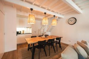 a dining room with a table and chairs and a clock at Azores Green Villas in Ponta Delgada