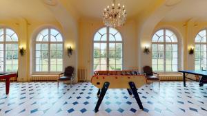 Habitación con mesa de ping pong y ventanas. en Tiny house du Château du Boulay-Morin en Le Boulay-Morin