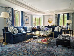 un soggiorno con divano blu e tavolo in vetro di The Dorchester - Dorchester Collection a Londra