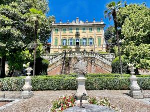 un edificio con una statua di fronte a un giardino di Antica dimora Villa Tatti-Tallacchini a Comerio