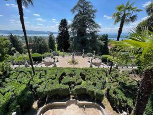 un giardino con cespugli, alberi e palme di Antica dimora Villa Tatti-Tallacchini a Comerio