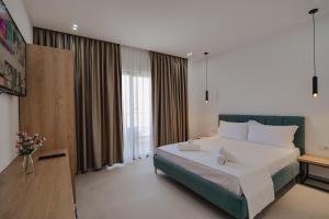 um quarto com uma cama grande e uma janela grande em Hotel Edola em Saranda