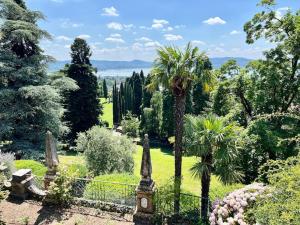 un giardino con statue e alberi e una recinzione di Antica dimora Villa Tatti-Tallacchini a Comerio