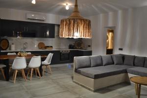 Erimo Vip في Vourvoúlos: مطبخ وغرفة معيشة مع أريكة وطاولة
