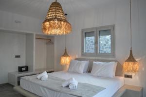 a bedroom with a white bed with two towels on it at Erimo Vip in Vourvoulos