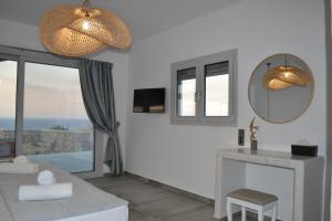 a white living room with a mirror and a table at Erimo Vip in Vourvoulos