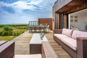 a patio with a couch and a table at Home Reach in Aldeburgh
