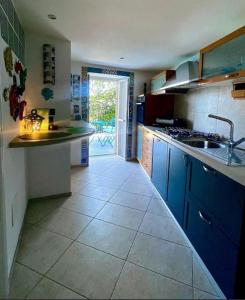 a kitchen with blue cabinets and a tile floor at Dimora Favale Guglielmi in Polignano a Mare