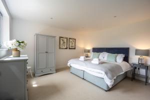 a bedroom with a large bed with a blue headboard at Home Reach in Aldeburgh