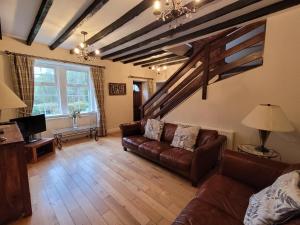 a living room with a couch and a tv at Dubh Loch Cottage in Rowardennan