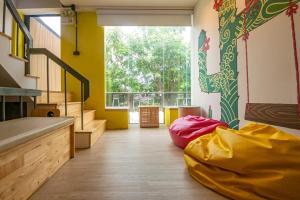 Zimmer mit gelben Wänden und einem großen Fenster in der Unterkunft Paknap Hostel in Nan