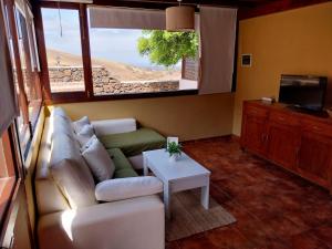 a living room with a couch and a tv and a table at Finca Esperanza in Yaiza