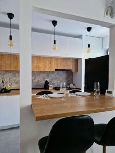 una cocina con una mesa con copas de vino. en Onix - Nordic Studio Apartment 3, Premium Parking en Bucarest