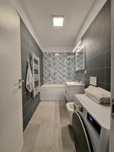 y baño con aseo, lavabo y bañera. en Onix - Nordic Studio Apartment 3, Premium Parking en Bucarest