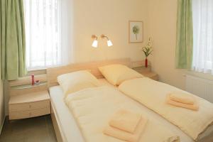 - une chambre avec 2 lits et des serviettes dans l'établissement Villa Sonnenstrand II, à Bansin