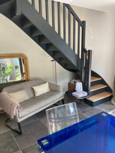 a living room with a couch and a staircase at Maison à Pornichet in Pornichet