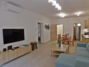 sala de estar con sofá azul y TV de pantalla plana en Berki Apartman, en Körmend